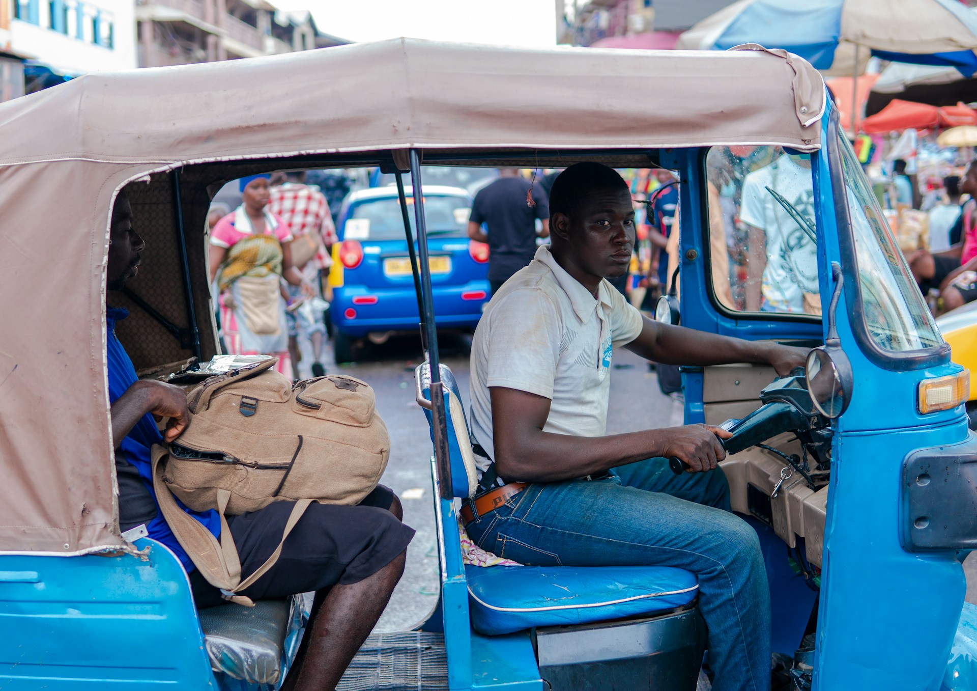 Motor tricycle transport operator in Ghana. Photo by Kojo Kwarteng @ Unsplash