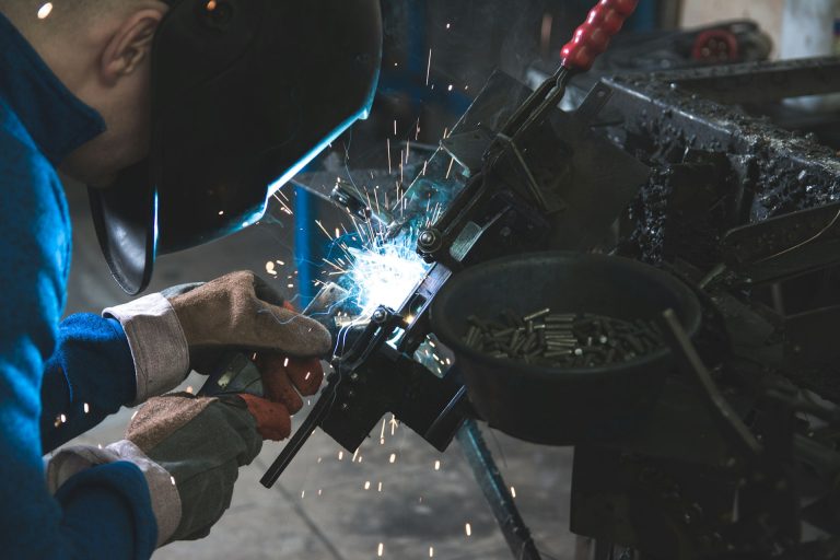 A welder at work in a factory. Photo by Daniel Wiadro @ Unsplash