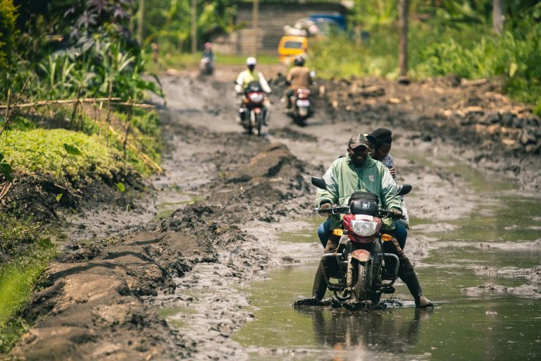 A muddy road in DR Congo. Photo by Dieuvain Musaghi @ Unsplash