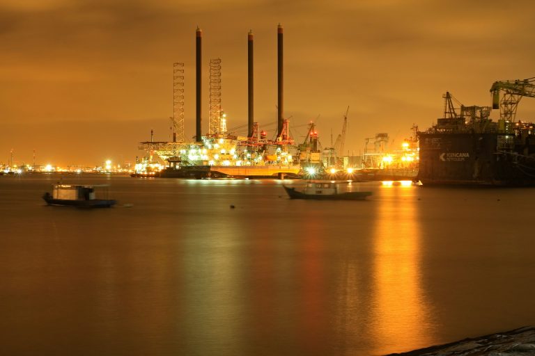 Image of oil refinery at night across the sea. Photo @Unsplash