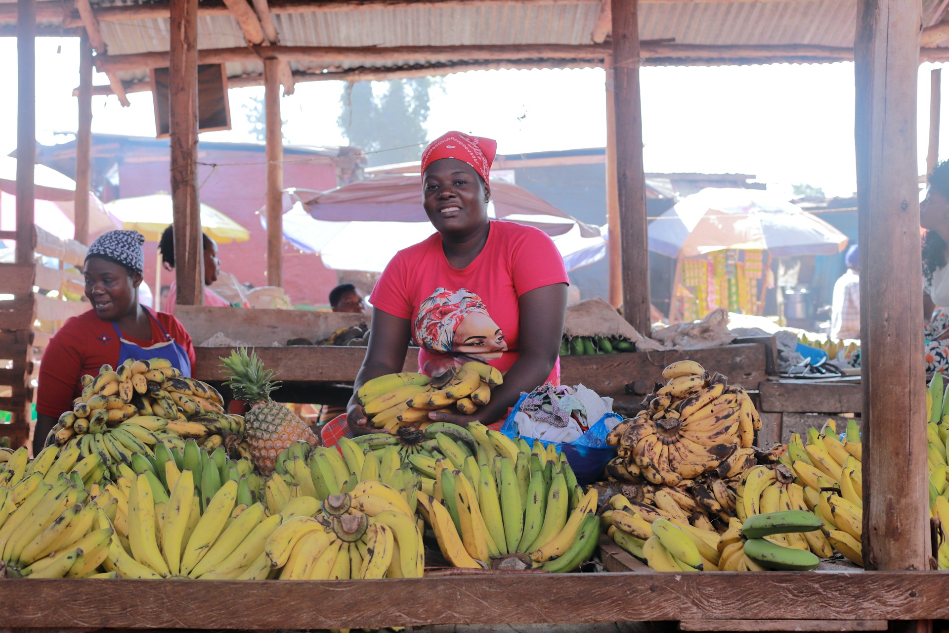 A woman selling bananas in a market. Photo by Andrew Itaga @ Unsplash