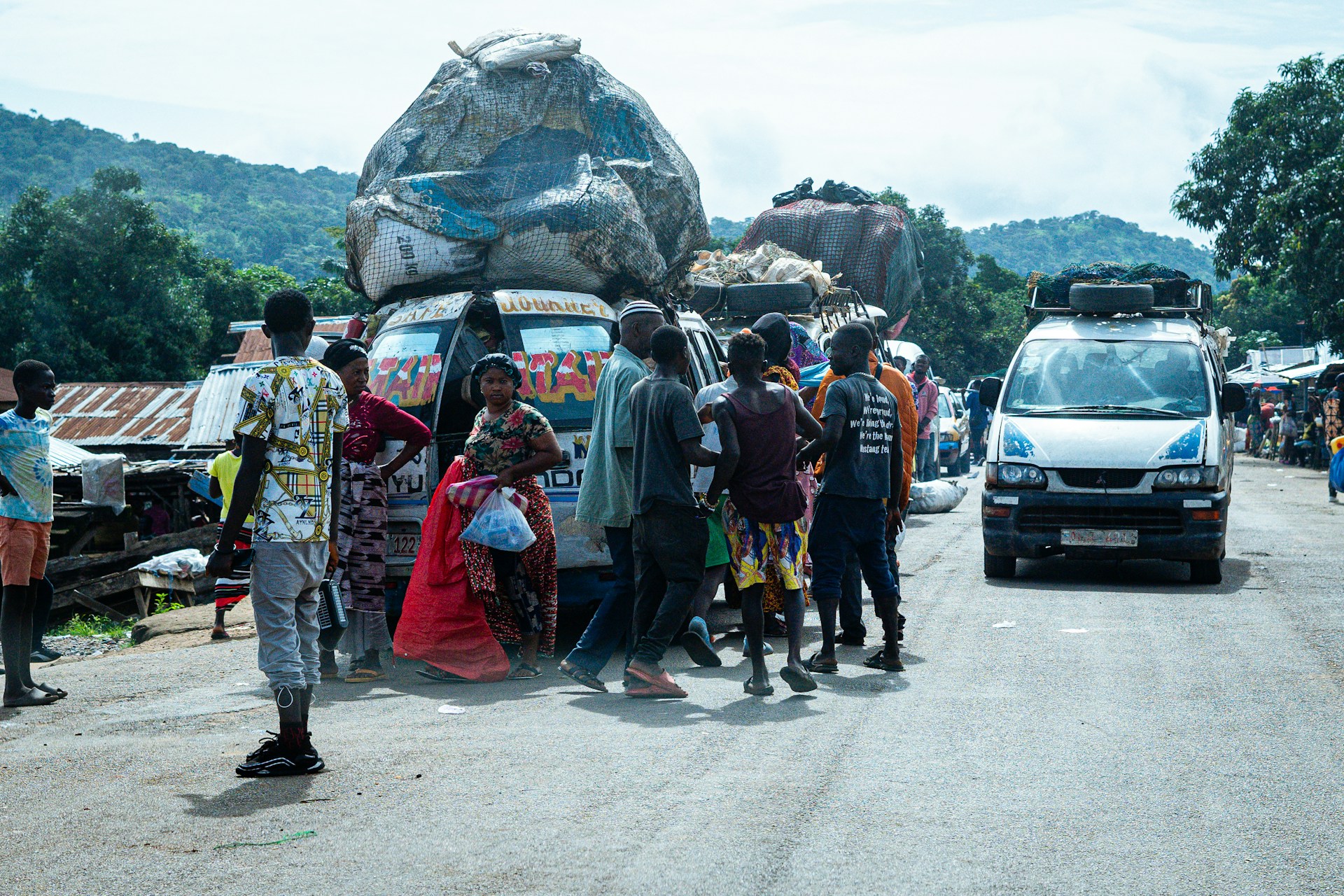 Passengers and hawkers at a street transport scene. Photo by Ümit Yıldırım @ Unsplash