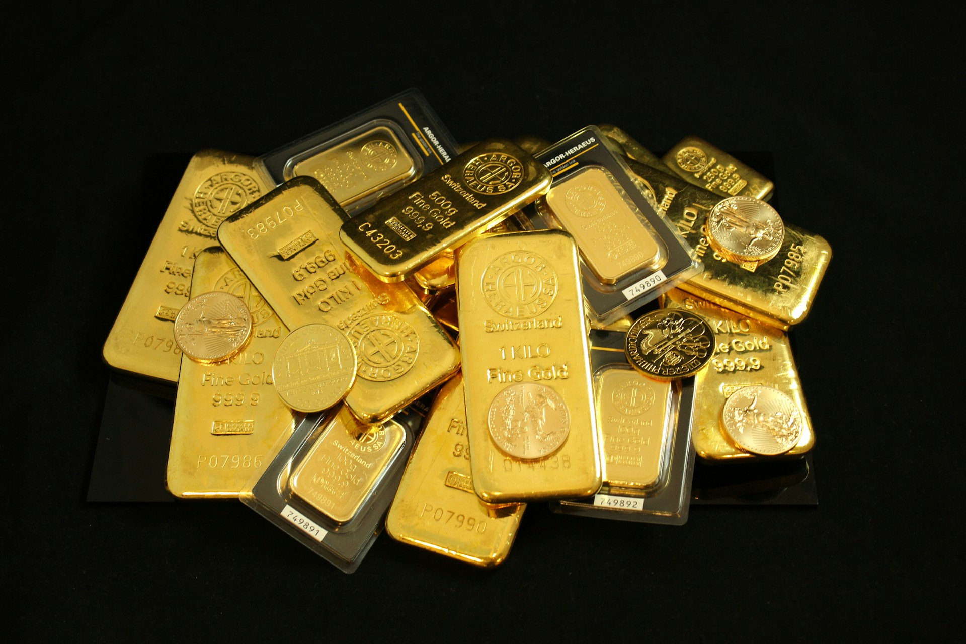Pile of gold bullion coins and bars. Photo by Zlaťáky @ Unsplash