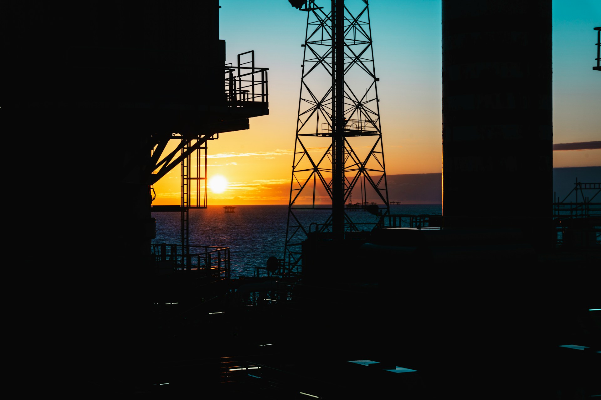 Offshore sunrise between the Crane and Communications tower on a Gas Platform. Photo by Dean Brierley @Unsplash