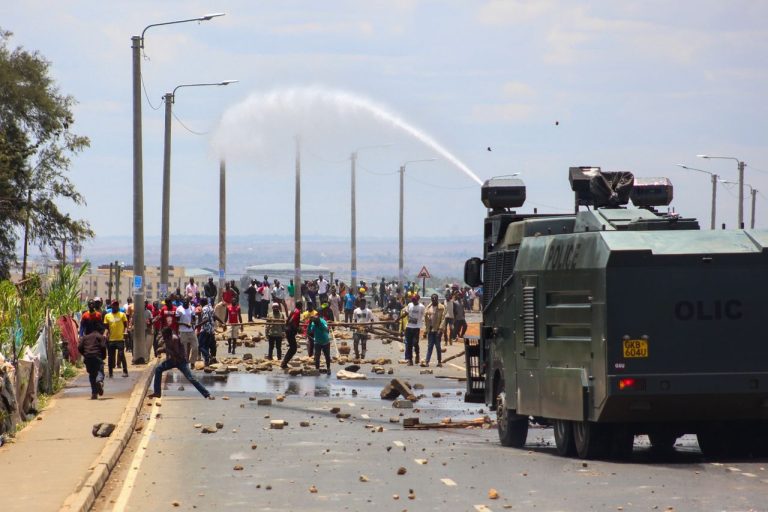 A tense protest scene in Nairobi, Kenya with a military vehicle using a water cannon against demonstrators. Photo by Stasham @ Pexels