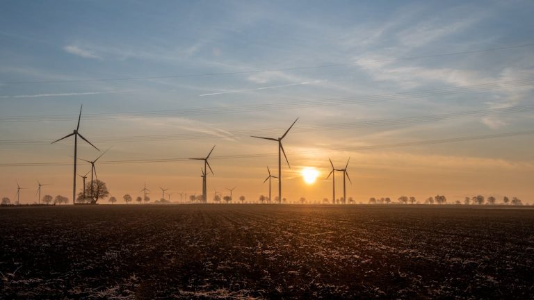A scenic view of wind turbines at sunrise, capturing sustainable energy. Photo by Lorna Pauli @Pexel