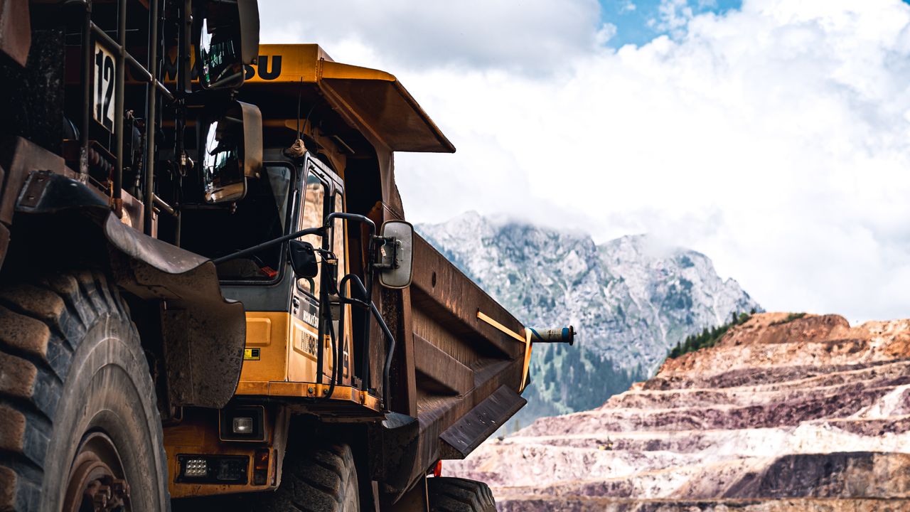 Large mining truck in a scenic mountain setting on a clear day. Photo by Usame Dzinovic @ Pexels