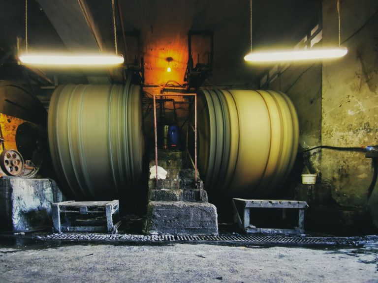 Large machinery operating inside a factory. Photo by Mehmet Turgut Kirkgoz @ Pexels