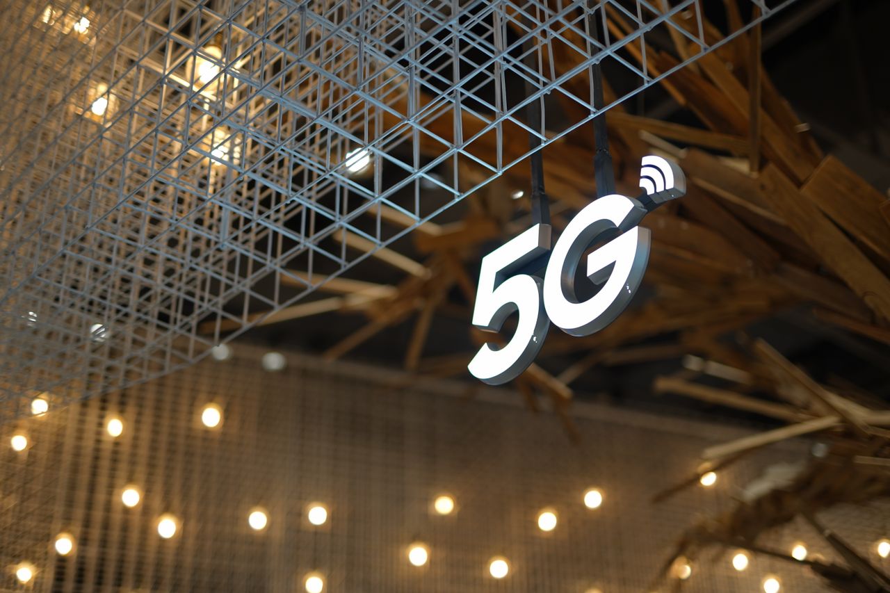 Illuminated 5G sign with modern geometric ceiling. Photo @ Pexels
