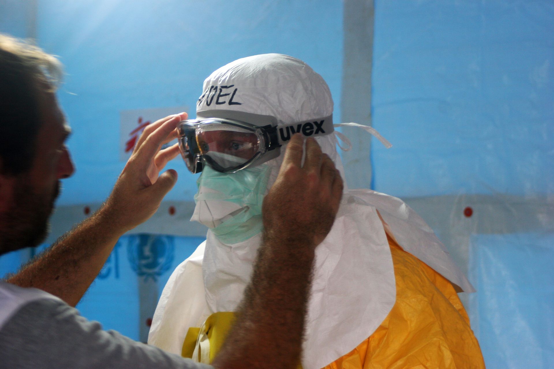 Healthcare worker puts on PPE gear in a medical facility for safety and protection. Photo by CDC @Pexels